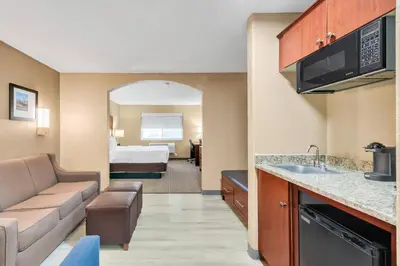 a hotel room with a kitchen and a living room at Comfort Suites Lakewood - Denver in Lakewood