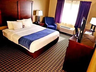 a hotel room with a bed and a chair and a television at Comfort Inn Fort Collins North in Fort Collins