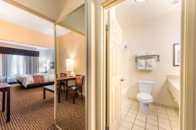 a hotel room with a bathroom with a bed and a toilet at Quality Inn & Suites University Fort Collins in Fort Collins