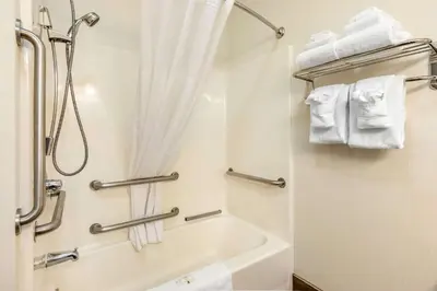 a bathroom with a shower and a bath tub with towels at Quality Inn & Suites University Fort Collins in Fort Collins