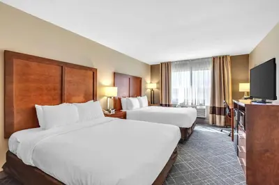 a hotel room with two beds and a flat screen tv at Comfort Inn Denver West Arvada Station in Wheat Ridge