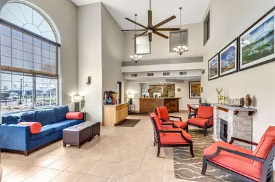 a living room with a blue couch and chairs at Comfort Inn Denver West Arvada Station in Wheat Ridge