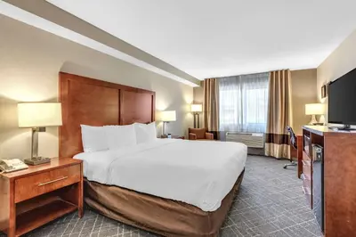 a hotel room with a large bed and a television at Comfort Inn Denver West Arvada Station in Wheat Ridge
