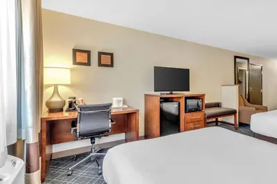 a hotel room with a bed and a desk with a television at Comfort Inn Denver West Arvada Station in Wheat Ridge