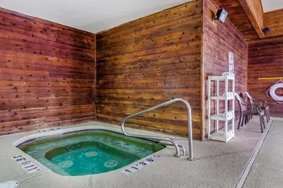a jacuzzi tub in a room with wooden walls at Comfort Inn & Suites Greeley in Greeley