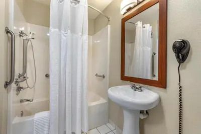 a bathroom with a sink and a shower with a mirror at Comfort Inn & Suites Greeley in Greeley