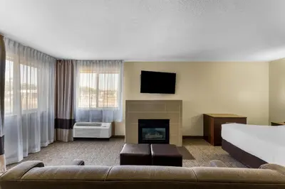 a hotel room with a couch and a fireplace at Comfort Inn & Suites Greeley in Greeley