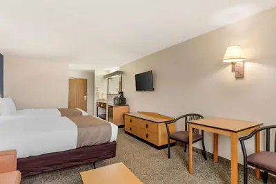 a hotel room with a bed and a table and chairs at Quality Inn & Suites Denver Airport - Gateway Park in Aurora