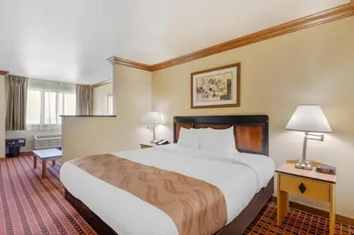 a hotel room with a large bed and two lamps at Quality Inn & Suites Denver Airport - Gateway Park in Aurora