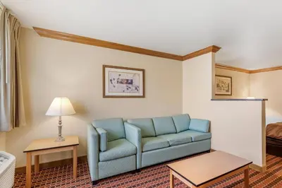 a living room with a blue couch in a hotel room at Quality Inn & Suites Denver Airport - Gateway Park in Aurora