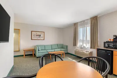 a living room with a couch and a table and chairs at Quality Inn & Suites Denver Airport - Gateway Park in Aurora