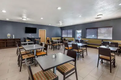 a restaurant with tables and chairs and a tv at Quality Inn & Suites Denver Airport - Gateway Park in Aurora