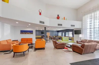 a lobby with chairs and tables in a building at Quality Inn & Suites Denver Airport - Gateway Park in Aurora