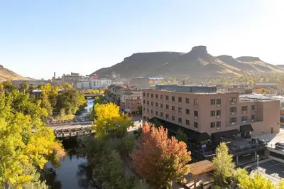 a city with a river and buildings and mountains at The Golden Hotel, an Ascend Collection Hotel in Golden