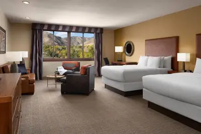 a hotel room with two beds and a chair at The Golden Hotel, an Ascend Collection Hotel in Golden