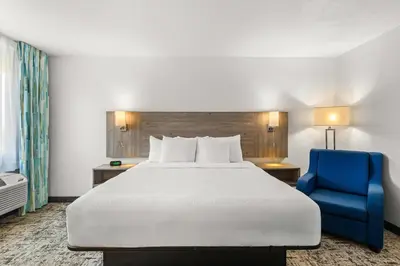 a hotel room with a bed and a blue chair at Quality Inn & Suites Denver International Airport in Denver