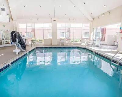 a swimming pool with blue water in a building at Quality Inn & Suites Denver International Airport in Denver