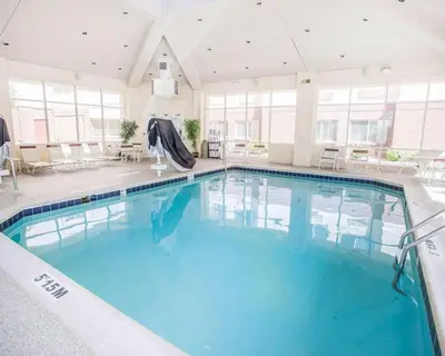 a large swimming pool with blue water in a building at Quality Inn & Suites Denver International Airport in Denver