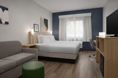 a hotel room with a bed and a couch at Spark by Hilton Lakewood Denver Southwest in Lakewood