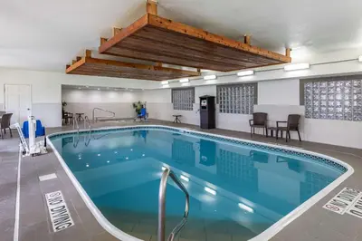 a large swimming pool with blue water in a building at Comfort Suites Fort Collins Near University in Fort Collins