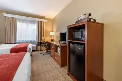 a hotel room with a bed and a television at Comfort Suites Fort Collins Near University in Fort Collins