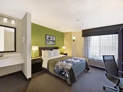a hotel room with a bed and a sink at Baymont by Wyndham Fort Collins in Fort Collins