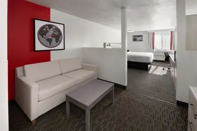 a living room with a couch and a bed at SYLO Hotel Denver Airport, a Ramada by Wyndham in Aurora