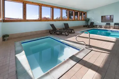 a pool in a house with a swimming pool at SYLO Hotel Denver Airport, a Ramada by Wyndham in Aurora