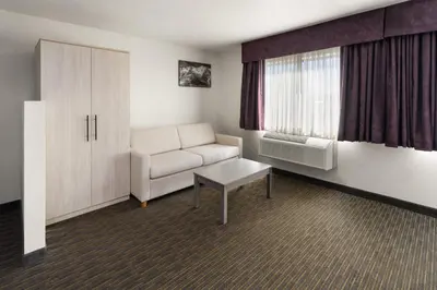 a living room with a couch and a window at SYLO Hotel Denver Airport, a Ramada by Wyndham in Aurora