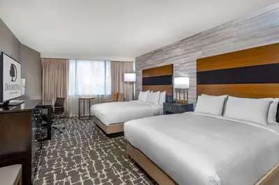 a hotel room with two beds and a desk at DoubleTree by Hilton Hotel Denver - Aurora in Aurora
