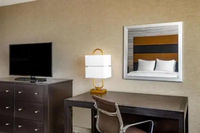 a hotel room with a desk with a television and a bed at DoubleTree by Hilton Hotel Denver - Aurora in Aurora