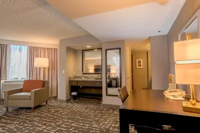 a hotel room with a desk and a mirror at DoubleTree by Hilton Hotel Denver - Aurora in Aurora