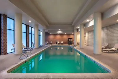 a pool in a hotel with tables and chairs at DoubleTree by Hilton Hotel Denver - Aurora in Aurora