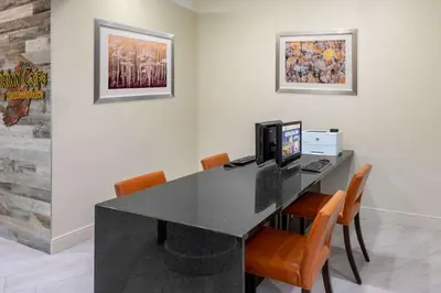 a black desk with a computer and orange chairs at DoubleTree by Hilton Hotel Denver - Aurora in Aurora
