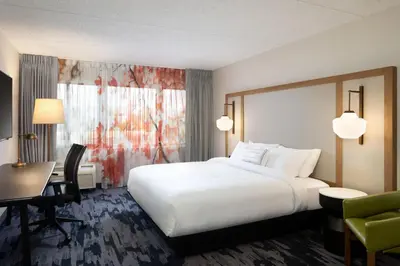 a hotel room with a large white bed and a desk at Fairfield Inn & Suites by Marriott Denver Southwest/Lakewood in Lakewood