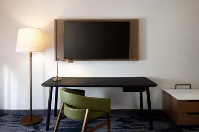 a room with a desk with a television and a chair at Fairfield Inn & Suites by Marriott Denver Southwest/Lakewood in Lakewood