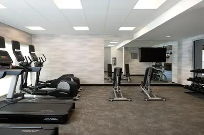 a gym with cardio machines and a flat screen tv at Fairfield Inn & Suites by Marriott Denver Southwest/Lakewood in Lakewood