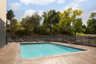a swimming pool with chairs and a fence at Fairfield Inn & Suites by Marriott Denver Southwest/Lakewood in Lakewood