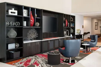 a living room with a tv on a wall at DoubleTree by Hilton Denver Tech in Greenwood Village