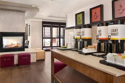 a hotel lobby with a coffee shop with a counter at Hampton Inn Denver-West/Golden in Golden