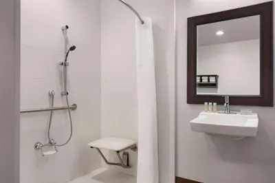 a bathroom with a shower and a sink and a mirror at Hampton Inn Denver-West/Golden in Golden