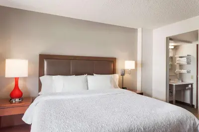a bedroom with a large bed and a red lamp at Hampton Inn & Suites Denver-Cherry Creek in Denver