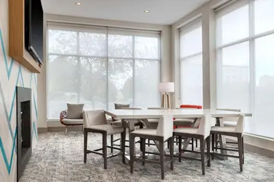 a dining room with a table and chairs and windows at Hilton Garden Inn Denver Airport in Aurora