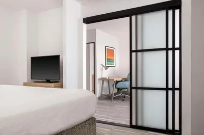 a bedroom with a bed and a tv and a desk at Hilton Garden Inn Denver Airport in Aurora