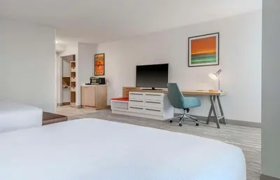 a bedroom with a bed and a desk with a television at Hilton Garden Inn Denver Airport in Aurora