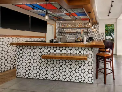 a kitchen with a bar with a white and black tiles at Hilton Garden Inn Denver Airport in Aurora