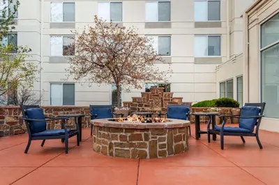a patio with chairs and a fire pit in front of a building at Hilton Garden Inn Denver Airport in Aurora