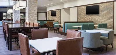 a dining room with tables and chairs in a restaurant at Embassy Suites Denver Tech Center in Centennial