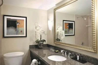 a bathroom with a sink and a mirror at Embassy Suites Denver Tech Center in Centennial