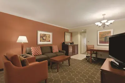 a living room with a couch and a desk at Embassy Suites Denver Tech Center in Centennial